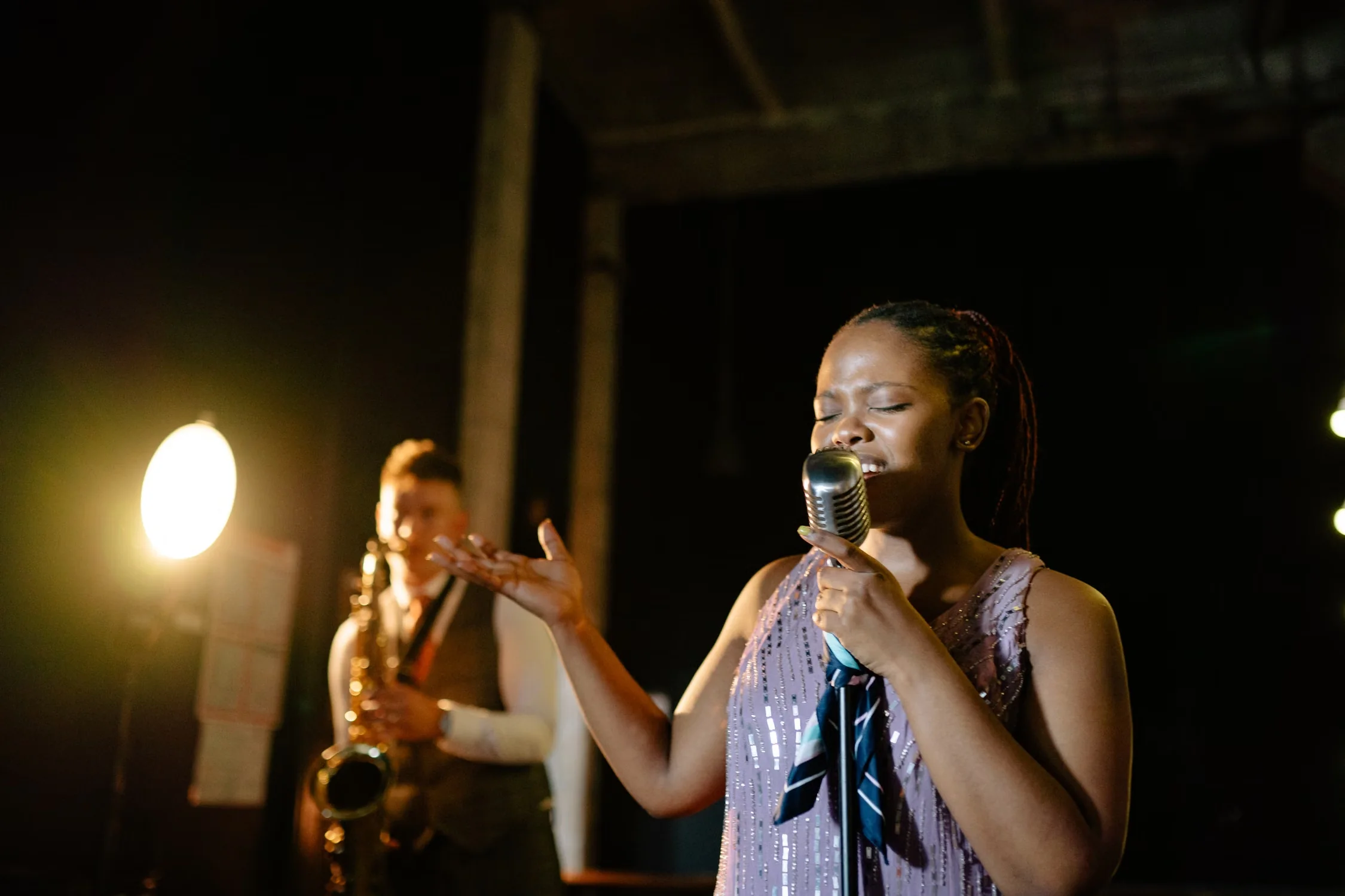 A jazz singer performing with a saxophonist on stage